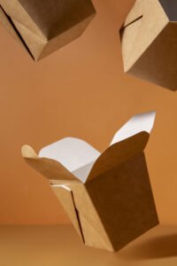 Embalagens sustentáveis em papel cartão caindo em um fundo laranja. Opções de Embalagens Sustentáveis